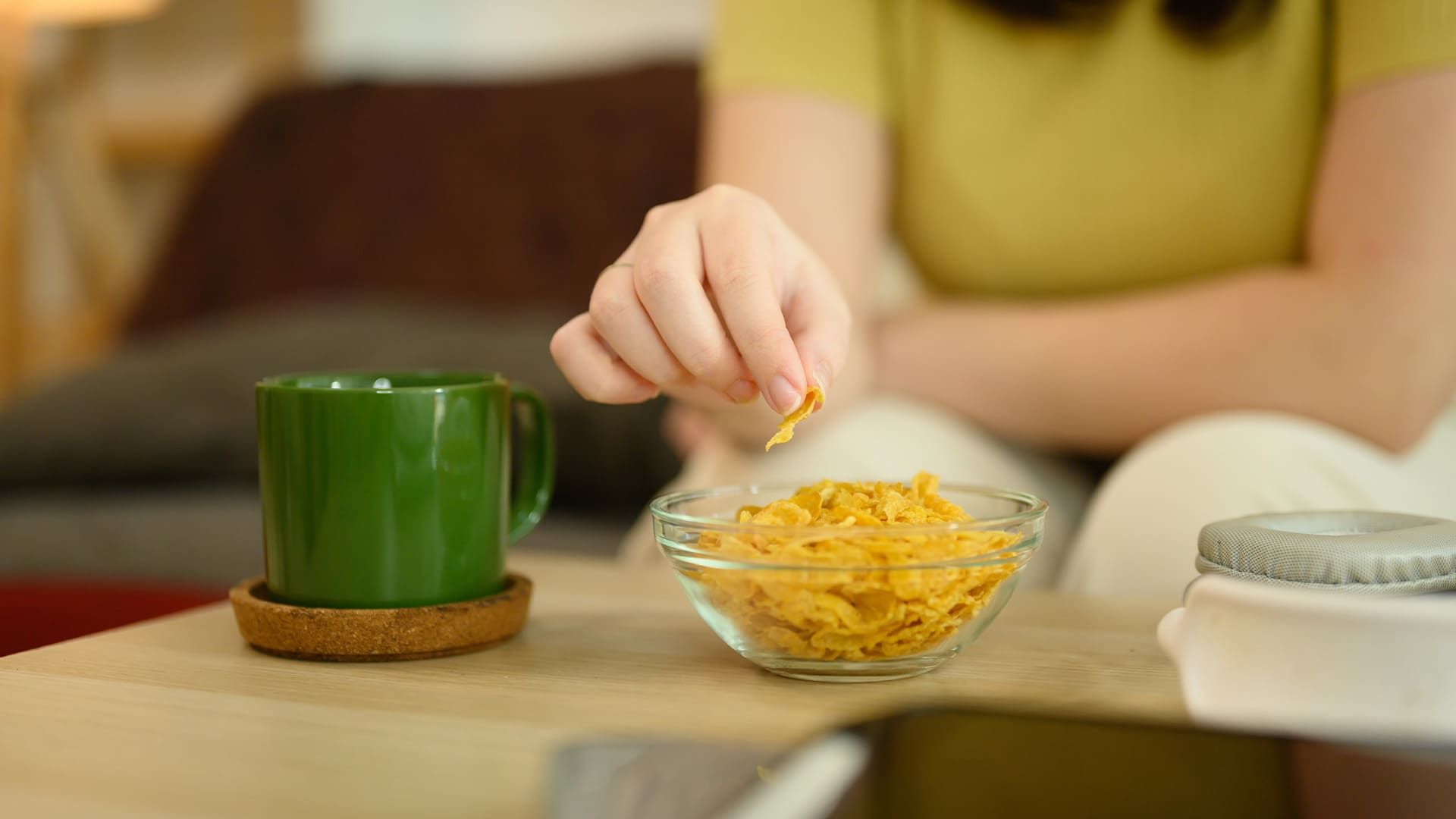 Personne grignotant devant une tasse, illustrant l’alimentation émotionnelle